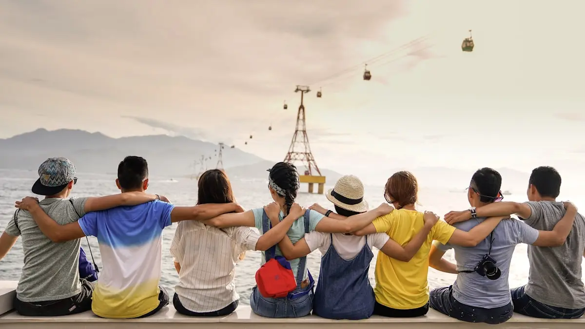 Friends sitting arm in arm on a wall